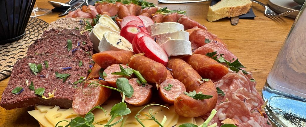 Brotzeitplatte mit Käse, Wurst, Radieschen und Brot im malBERGBLICK